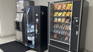 Deux distributeurs automatiques : l’un distribue de l’eau, l’autre des collations.