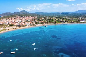 A coastal town with a beach, boats, and a pier.