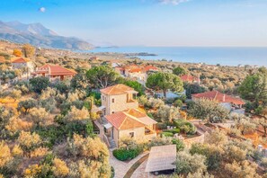 A coastal village with stone buildings, terraced gardens, and a view of the sea. - Villa Panorama - Three Bedroom Villa, Sleeps 6 (Ditiki Mani)