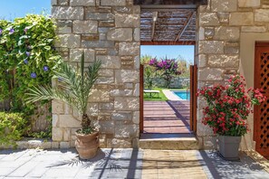 Una entrada de piedra con vistas a una piscina y jardín.