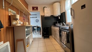 Una cocina con cafetera, estufa y refrigerador.