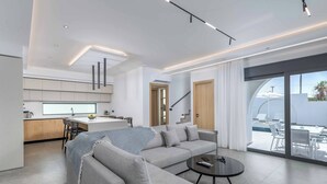 A modern living room with a sofa, coffee table, and a view of the outdoors.
