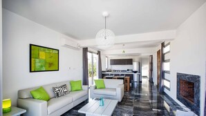 Una sala de estar moderna con un sofá, una mesa de centro y una obra de arte en la pared.