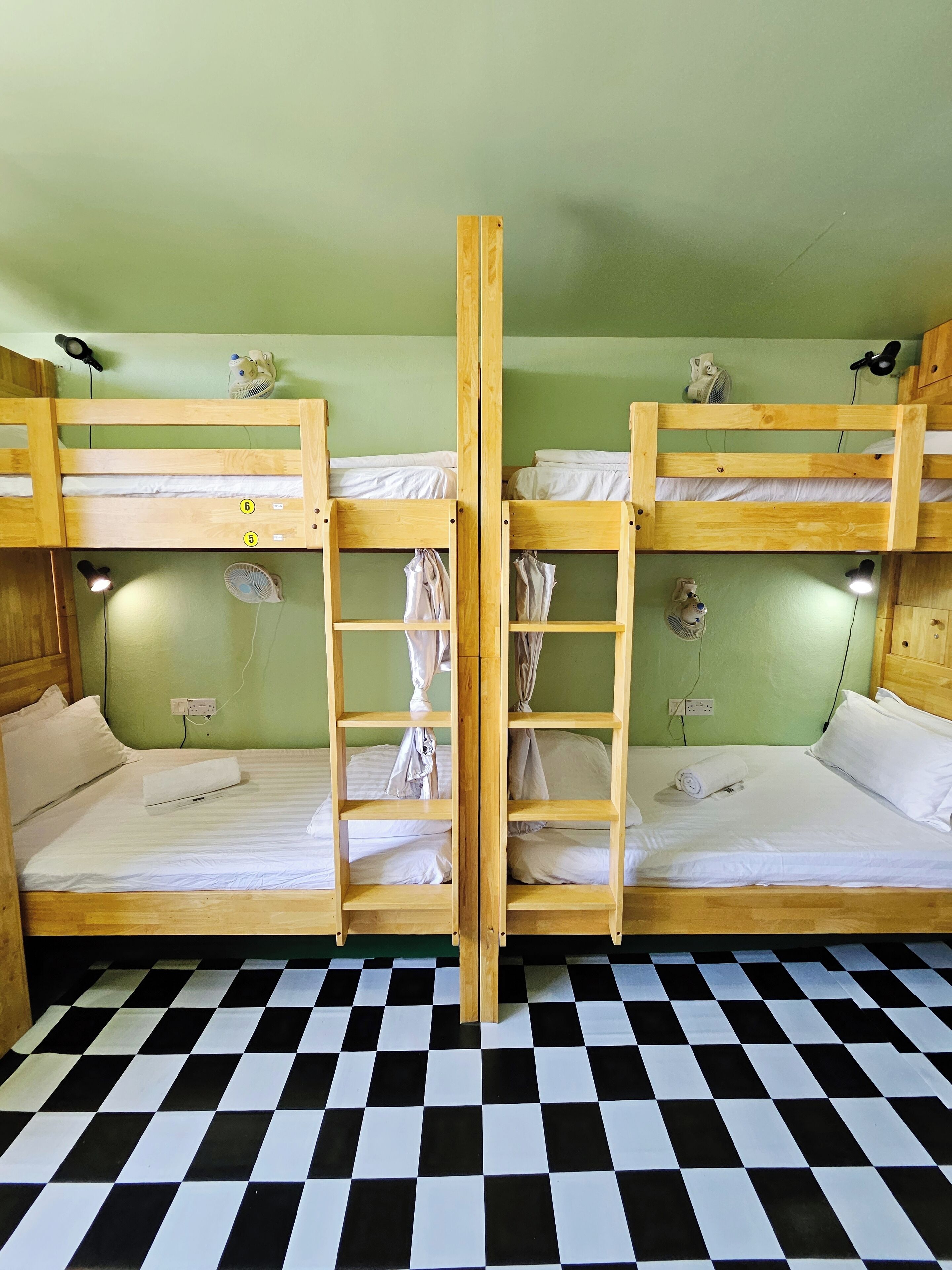 A room with two bunk beds, a checkered floor, and a ladder connecting the beds.
