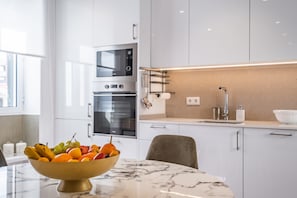 Enjoy cooking in this well-equipped kitchen with oven, microwave, and marble countertop.