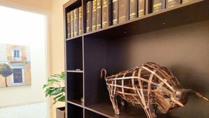 A bookshelf with leather-bound books and a sculpture of a bull. - Comfortable apartment in Syntagma square (Athina)
