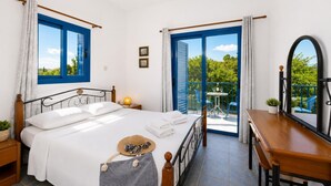 A bedroom with a bed, a desk, a chair, a window, and a balcony with a table and chairs. - Villa Rotiana - Three Bedroom Villa, Sleeps 6 (Poli Crysochous)