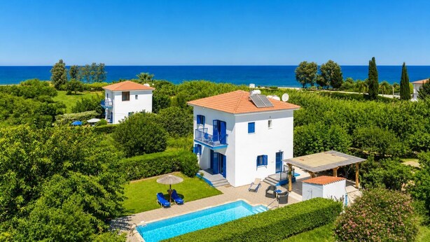 A white building with blue accents, a swimming pool, and a view of the sea. - Villa Rotiana - Three Bedroom Villa, Sleeps 6 (Poli Crysochous)