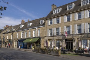 A row of traditional buildings with a pub and a hotel. - An inviting and warm, dog friendly holiday cottage - Snowdrop Cottage (Chipping Norton)