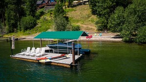 A dock with a covered seating area, a boat, and a small rowboat. - Lake Front New Remodel w/ Hot Tub- Coeur d'Alene (Coeur d'Alene)