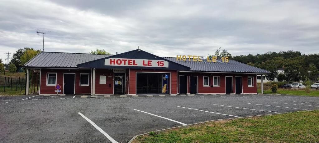 Un edificio rojo con un letrero que dice "HOTEL LE 15".