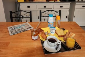 A breakfast tray with croissants, toast, jam, coffee, and orange juice on a wooden table. - Hôtel le 15 (Coulounieix-Chamiers)