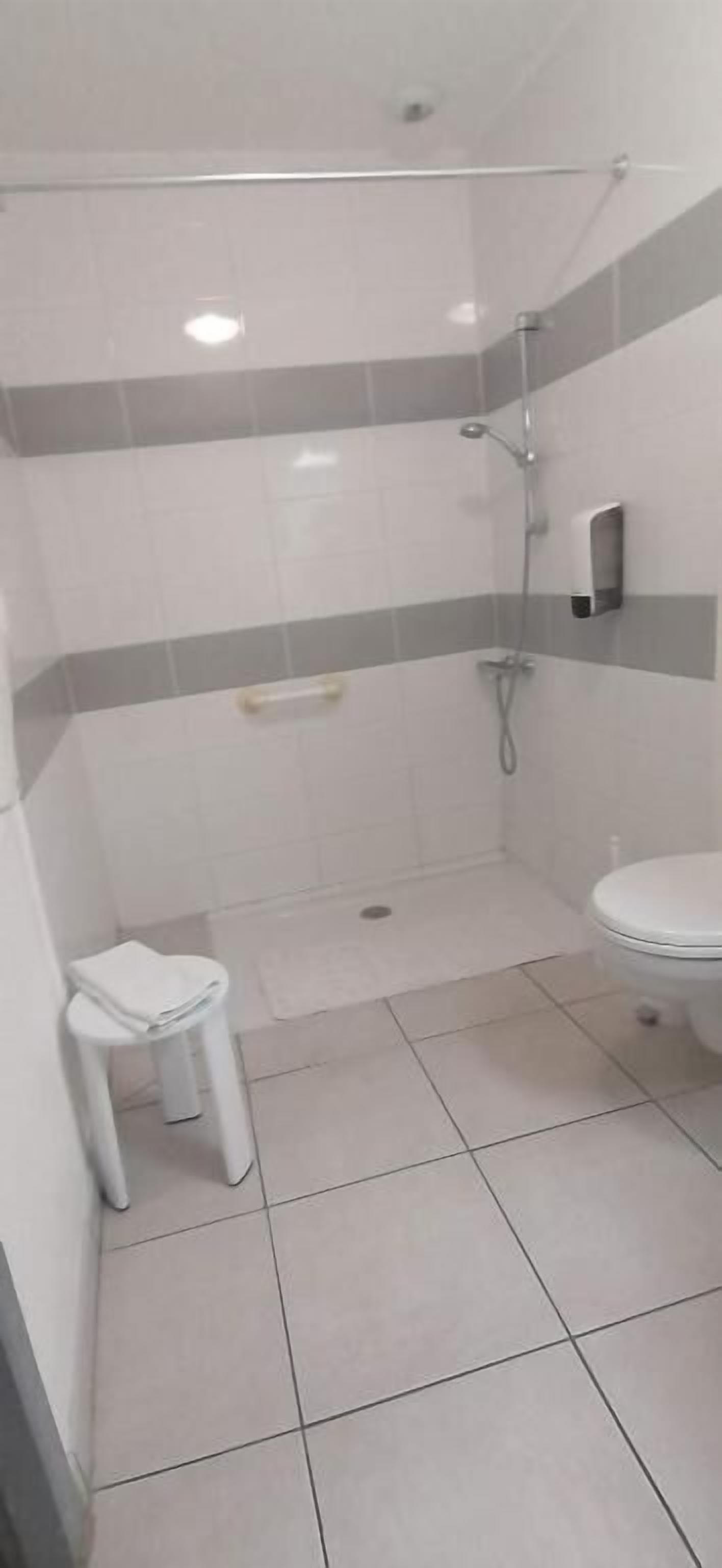 A bathroom with a shower, toilet, and sink.