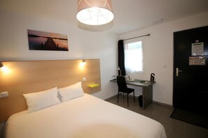 A hotel room with a bed, desk, chair, and a painting on the wall. - Hôtel le 15 (Coulounieix-Chamiers)