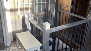 A rustic interior with a wooden staircase, a white table, and a patterned rug. - Inn the Barn (Conestoga)