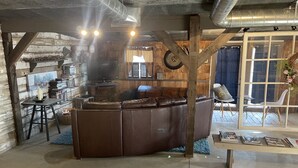A rustic interior with a central seating area, wooden walls, and a visible chimney. - Inn the Barn (Conestoga)
