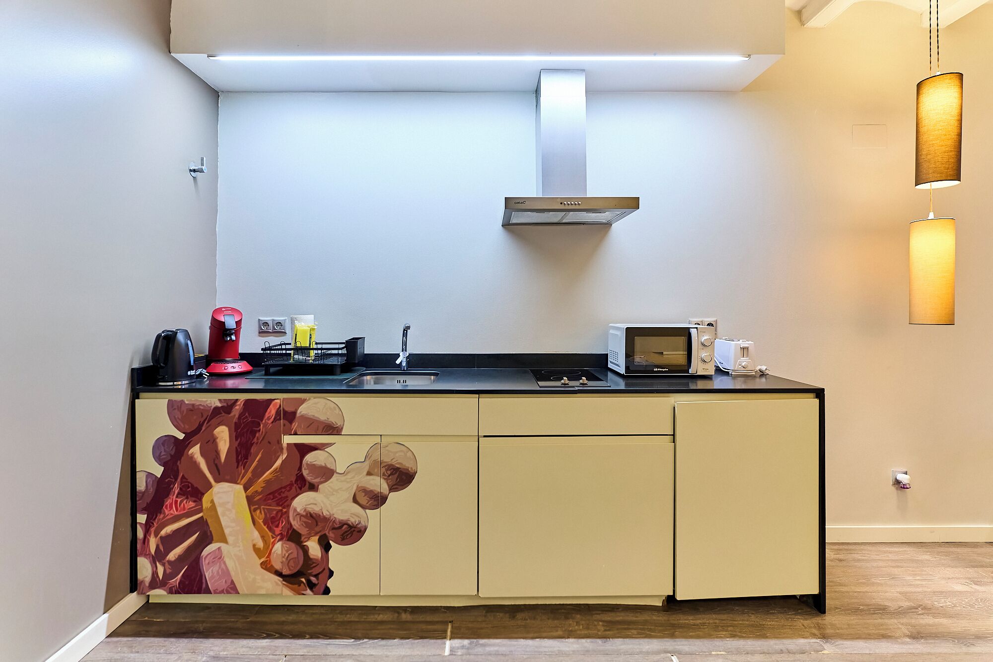 A modern kitchen with a stainless steel range hood, a microwave, and a toaster on the countertop.