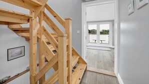 A wooden staircase leading to a balcony with a view of greenery. - The Old Pilot Hut, Felixstowe Ferry, Amazing Views (Felixstowe Ferry)