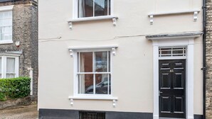 A two-story building with a black door and white-framed windows.