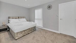 Une chambre à coucher avec un lit, une table de chevet et une porte.