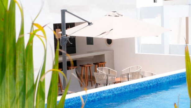 A pool area with a white umbrella, white chairs, and a bar area. - 2 BD w/ Private Plunge Pool + Terrace (Tulum)