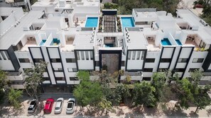 A modern residential complex with multiple buildings, a central courtyard, and a swimming pool.