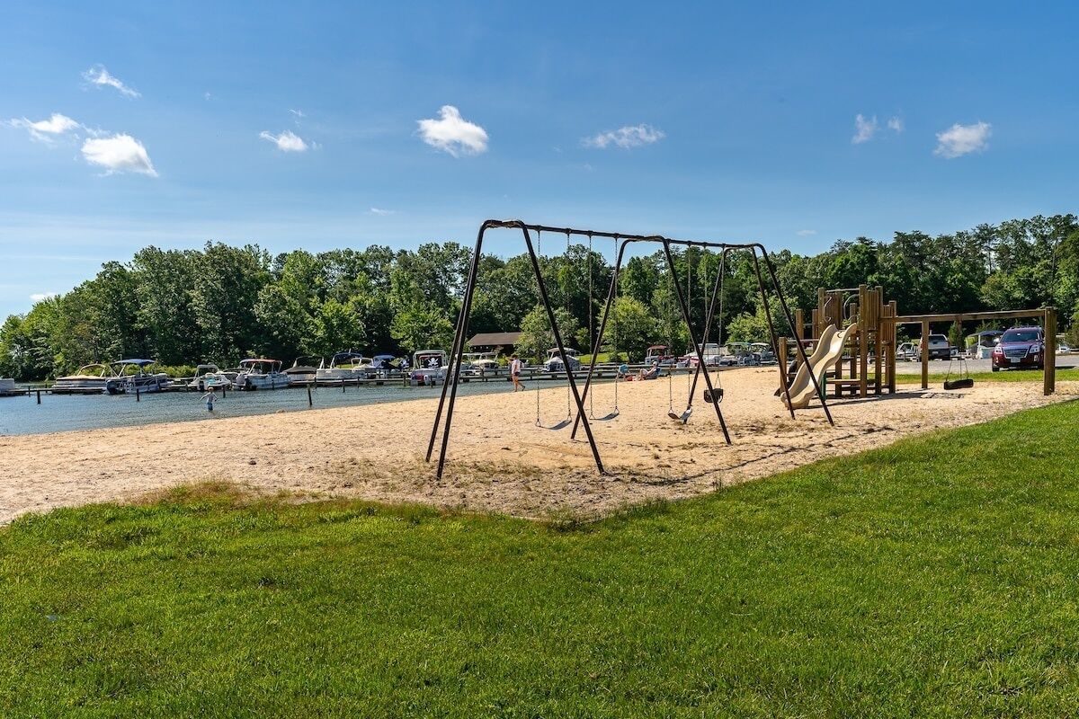 Ein Strand mit einer Schaukel und einem Spielplatz.
