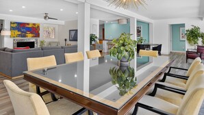 A modern dining area with a glass-top table, cushioned chairs, and a decorative ceiling light. - Casa Del Sol, a private Palm Springs Oasis (Palm Springs)