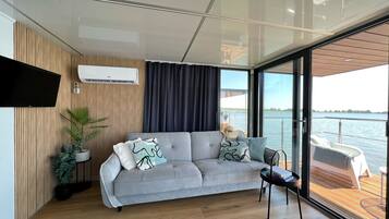 A modern living area with a sofa, a small table, and a potted plant.