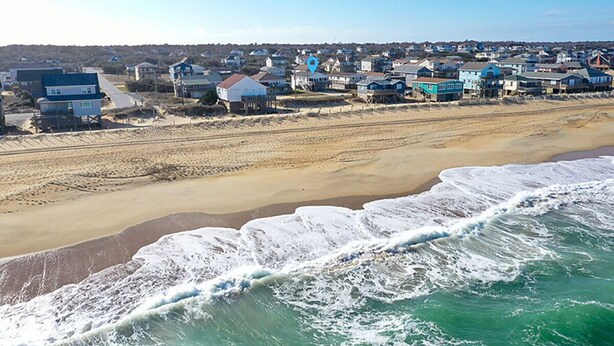 A coastal town with beachfront properties, sandy beaches, and ocean waves.