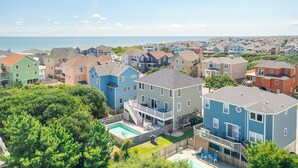 Un quartier résidentiel avec des maisons, une piscine et une vue sur l’océan.