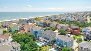 Une zone résidentielle côtière avec des maisons, une plage et un ciel dégagé.