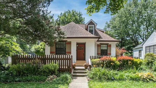 A single-story house with a front porch, a picket fence, and a well-maintained garden. - Music Room Basement Apartment w/ Private Entrance (Springfield)