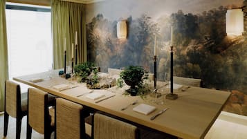 A dining room with a long table set for six, surrounded by chairs.