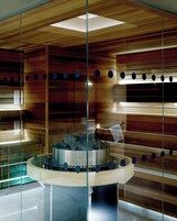 Un interior moderno con calefacción central, paneles de madera y un separador de vidrio con aberturas circulares.