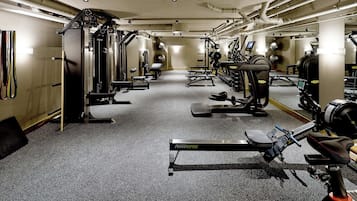 Un gimnasio con equipo de ejercicio variado, incluyendo cintas de correr y máquinas de pesas.