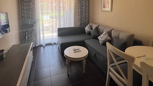 A living room with a sofa, a round table, a TV, and a fan. - Porto sharm elsheikh  (Sharm El Sheikh)