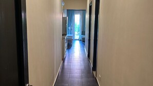 A hallway with dark tiled flooring, beige walls, and a ceiling light. - Porto sharm elsheikh  (Sharm El Sheikh)