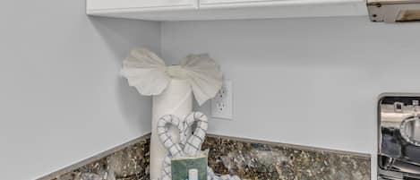 Un baño con encimera de mármol, un rollo de papel higiénico blanco y una caja de pañuelos.
