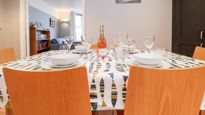 A dining area with a table set for four, a bookshelf in the background, and a wall sign that reads "FISH AND CHIPS". - 11 The Craighurst (Reydon)