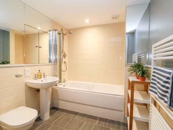 Un baño moderno con bañera, lavamanos e inodoro.