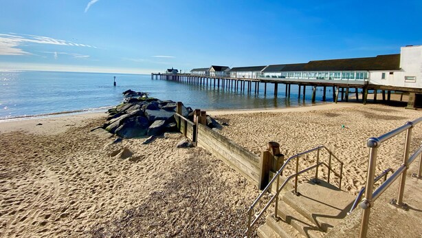 A beach with a wooden jetty extending into the sea, a staircase leading to a building, and a clear sky. - 11 The Craighurst (Reydon)