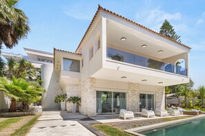 A modern two-story house with a swimming pool, outdoor seating, and a view of the surrounding area. - Luxury Villa with Pool,BBQ and Garden Vouliagmeni
 (Voula)