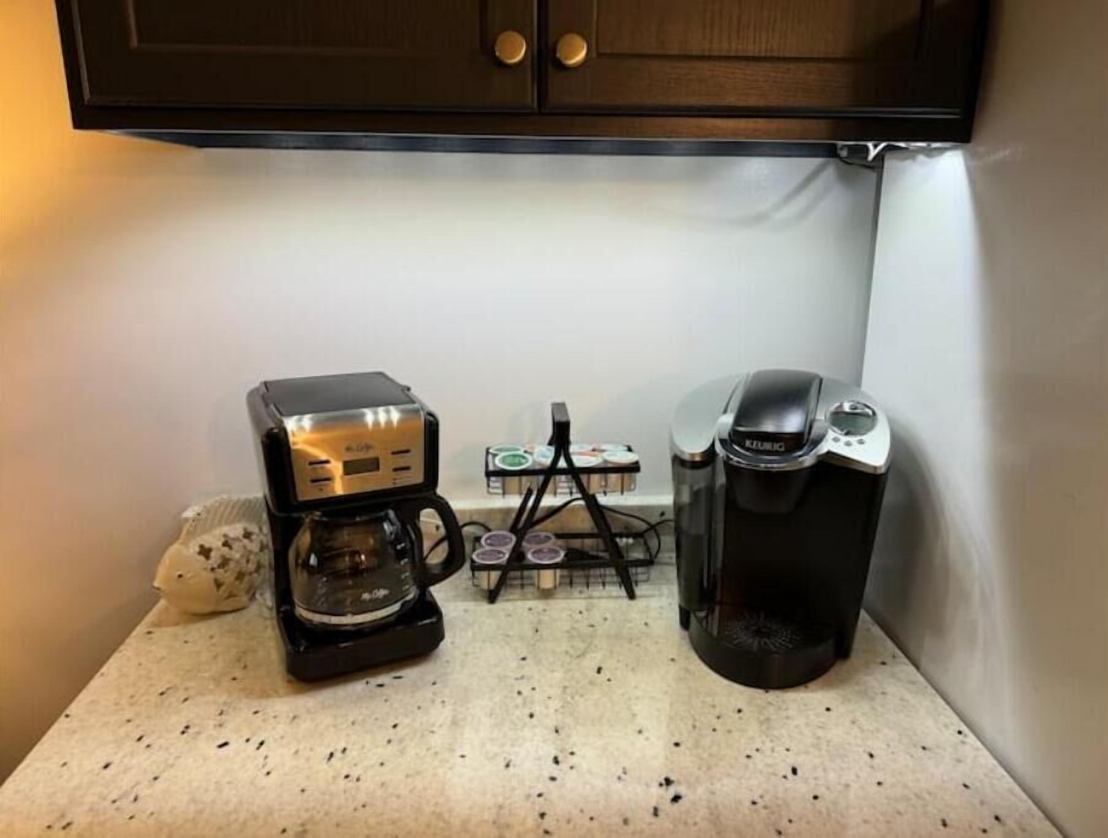 Eine Küchenzeile mit Kaffeemaschine und Mixer auf einer Arbeitsplatte.