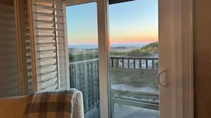 Una stanza con vista sulla spiaggia e sull'oceano al tramonto.