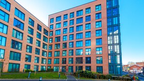 A modern building with a symmetrical facade, large windows, and a clear sky.