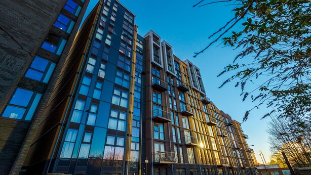 En byggnad med flera våningar och en modern arkitektonisk design, med stora fönster och balkonger.