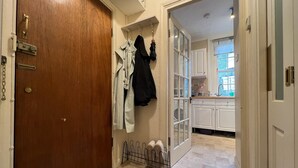 A hallway leading to a kitchen with white cabinets and a window. - Beautiful 1-bed Apartment in London (London)