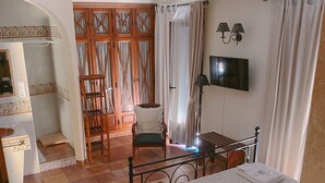 A bedroom with a bed, a chair, a desk, and a TV. - Casa Lares (Casas de Don Pedro)
