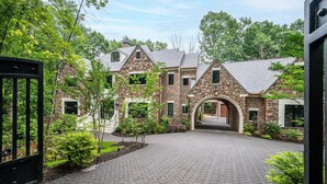 A stone building with a brick driveway and a gated entrance.